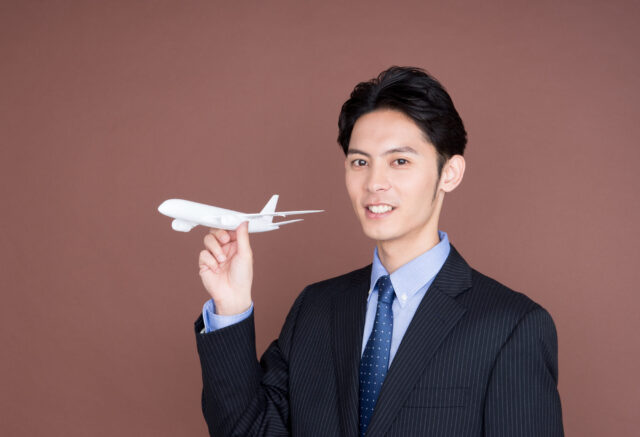 飛行機の模型を持つビジネスマン