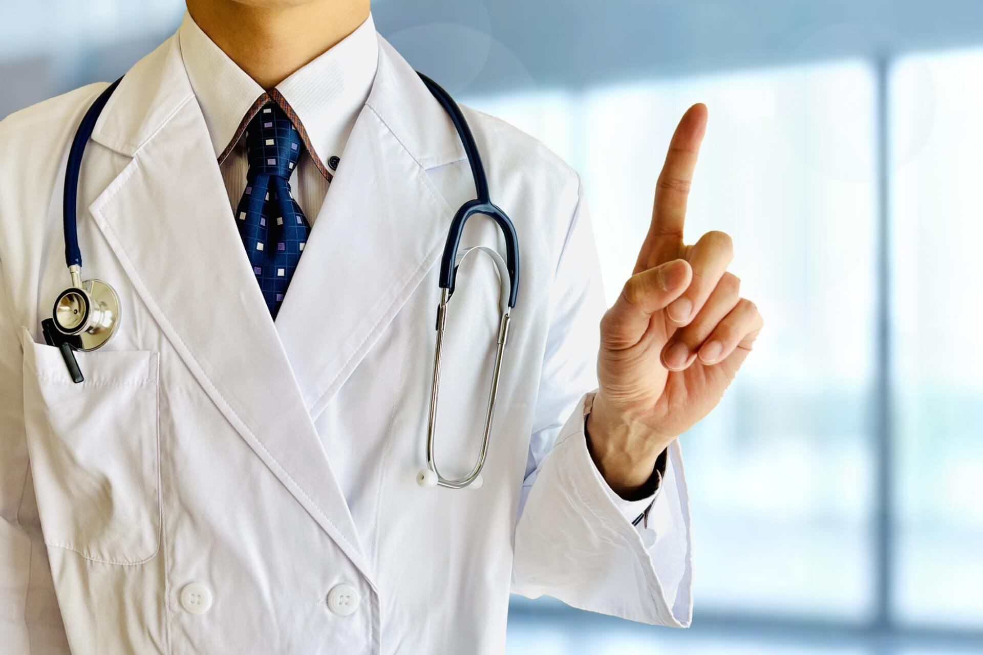 指をさす医者